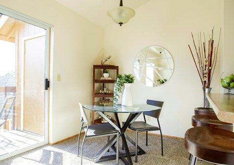 A dining room with a glass table and chairs.