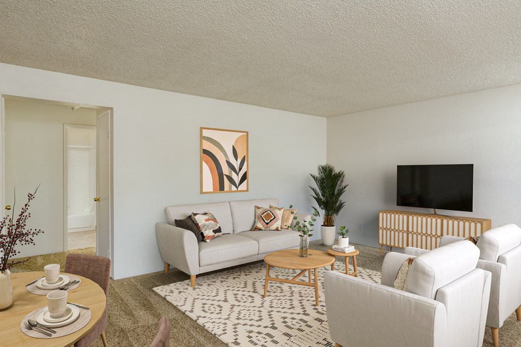 a living room with white furniture and a tv