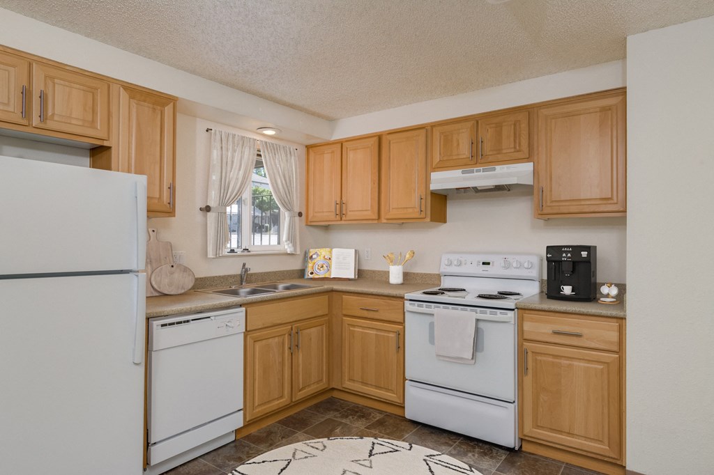 a kitchen with white appliances and wooden cabinets