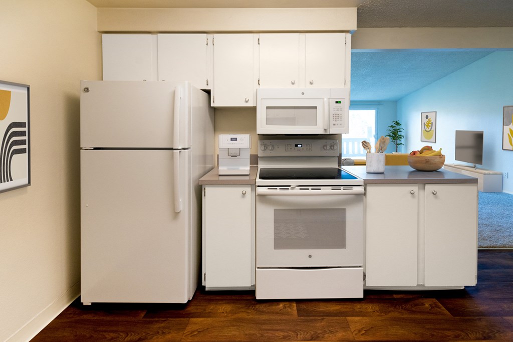 a kitchen with white cabinets and appliances and a white refrigerator