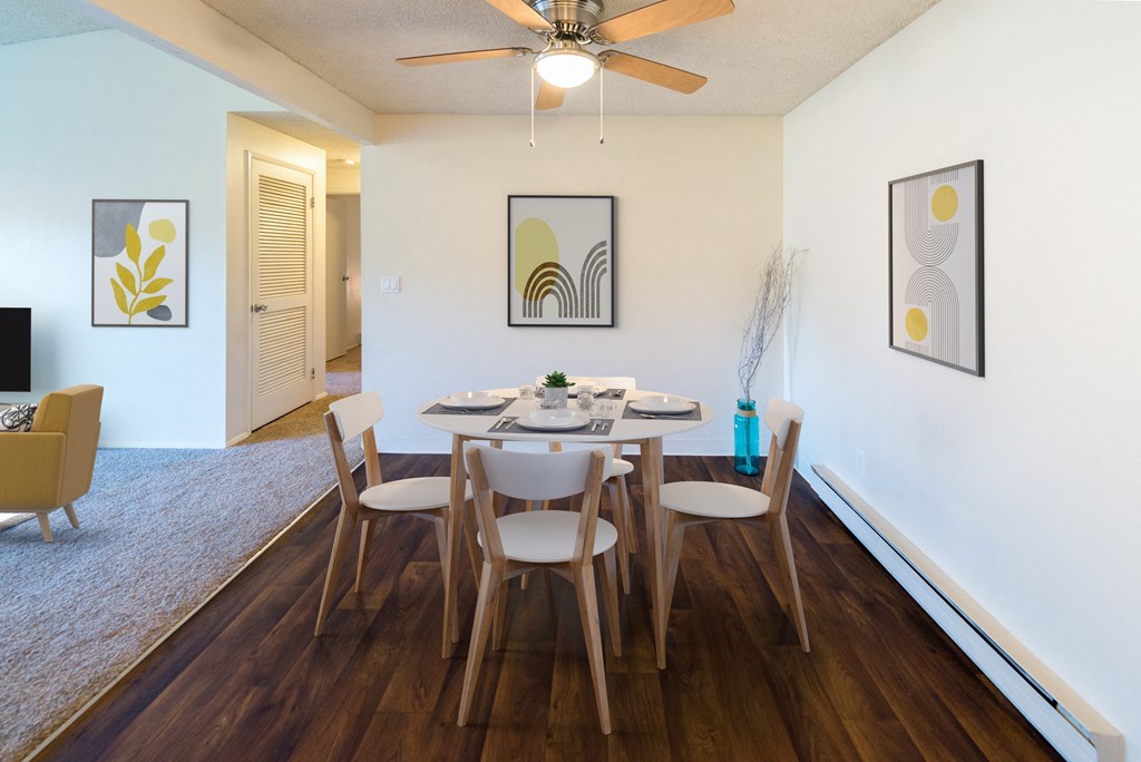 a dining room with a table and chairs and a ceiling fan