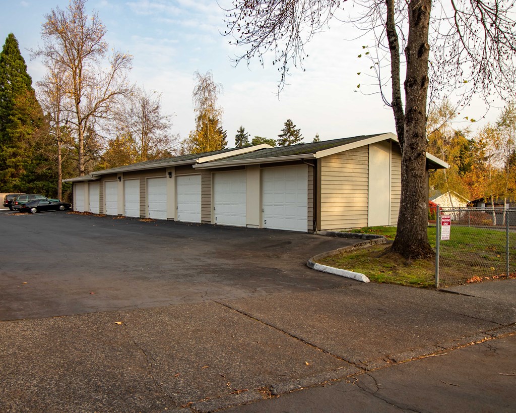 a building with white garage doors and a tree