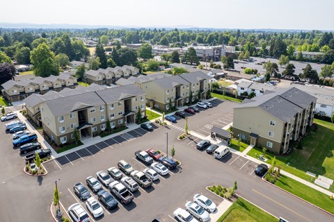 A parking lot with cars and apartment buildings in the background.