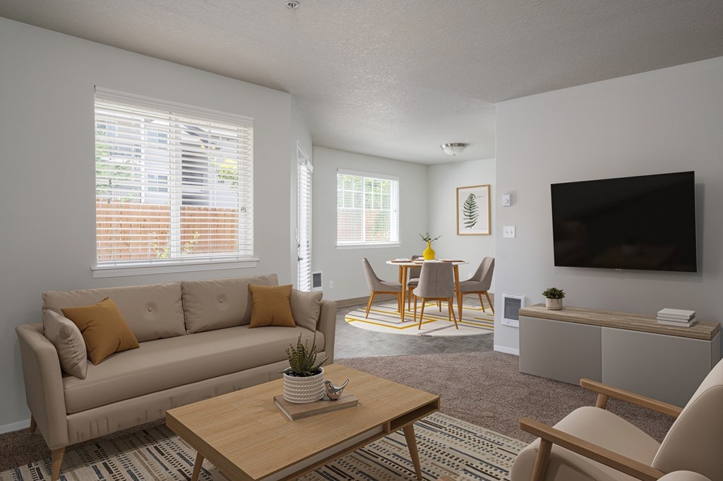 A living room with a couch, chairs, and a television.