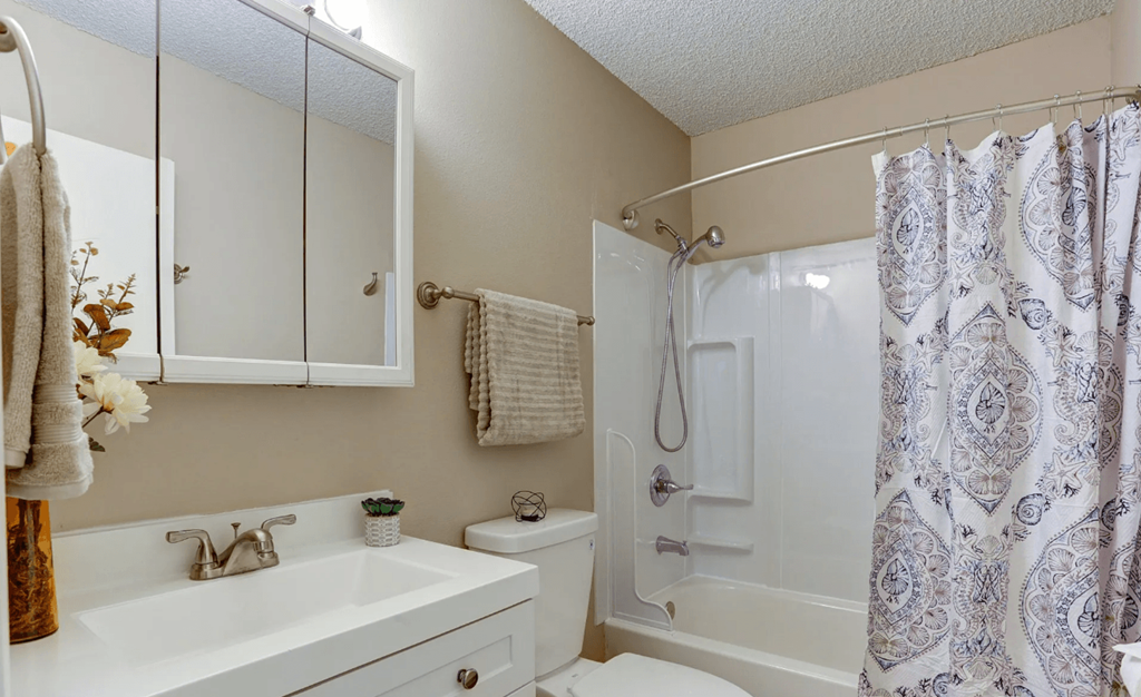 a bathroom with a shower and a sink and a toilet