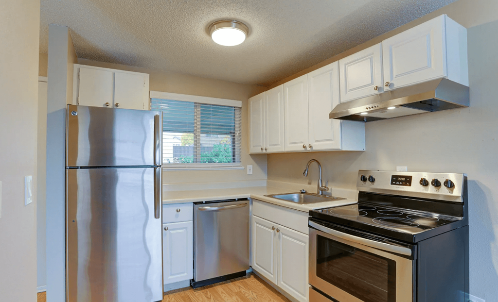a kitchen with stainless steel appliances and white cabinets