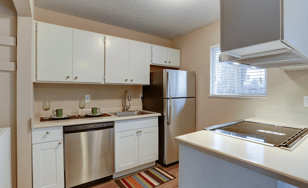a kitchen with white cabinets and a stainless steel refrigerator
