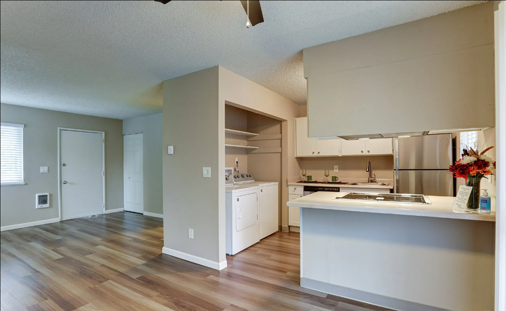 an empty kitchen with white cabinets and a wood floor
