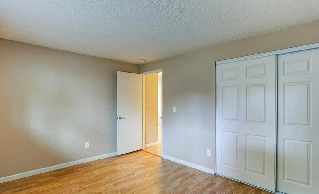 a empty room with white doors and a door to a closet