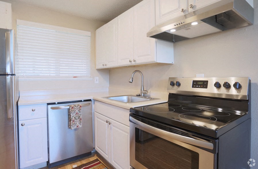 a kitchen with stainless steel appliances and white cabinets