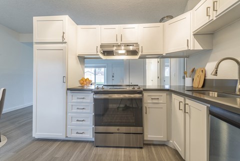 a kitchen with white cabinets and a stainless steel stove