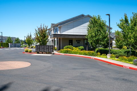 A modern building with a white facade and a red curb in front.