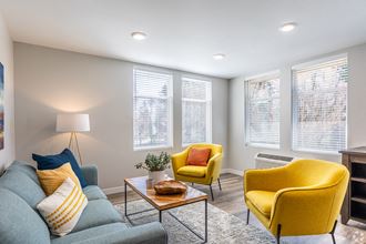 a living room with yellow chairs and a blue couch