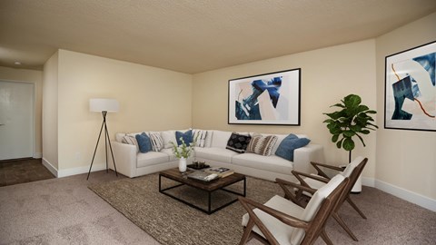 A living room with a white couch, a coffee table, and two abstract paintings on the wall.