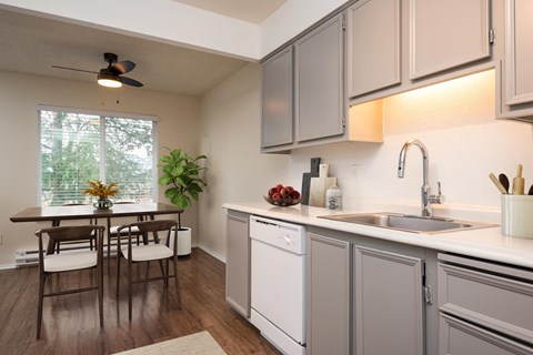 A kitchen with a table and chairs by a window.