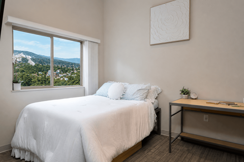 A bedroom with a large bed and a view of the city.