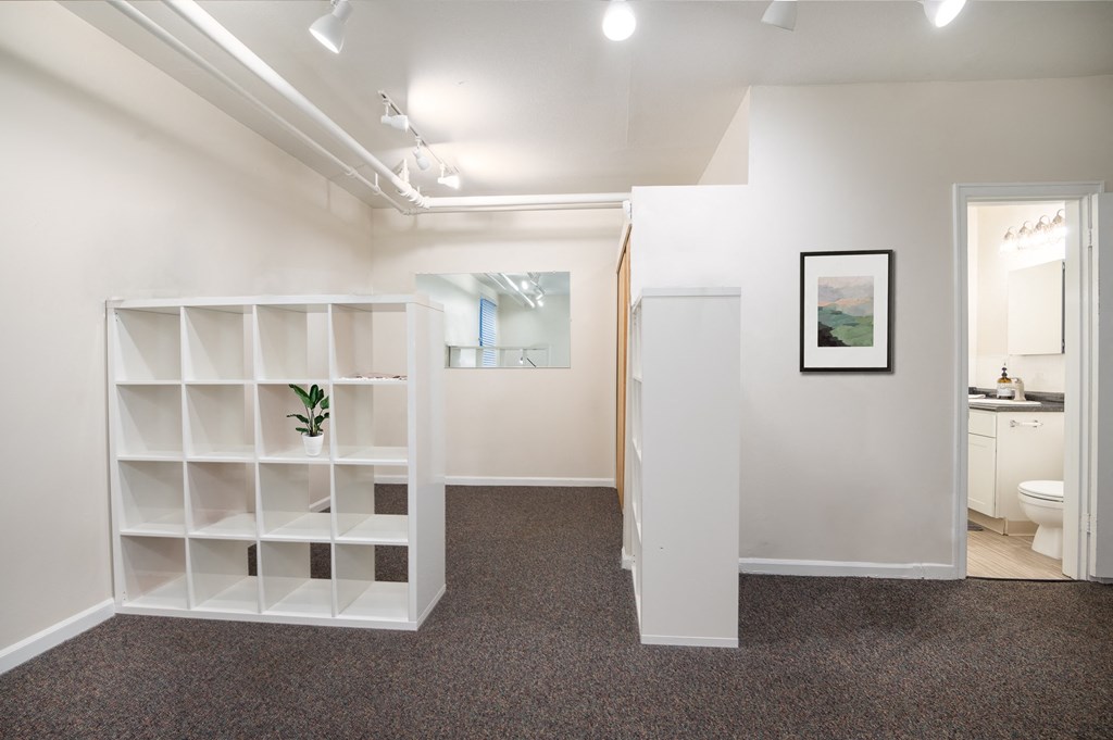 a room with a white shelving unit and a bathroom