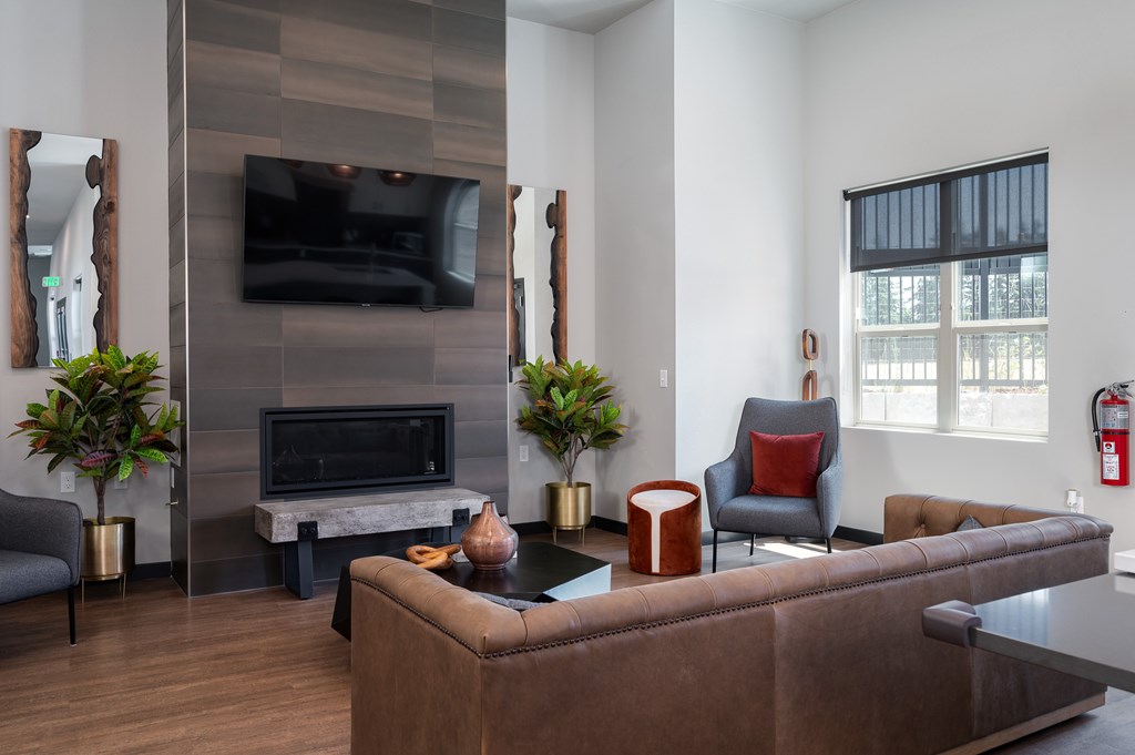 A living room with a brown couch and a fireplace.