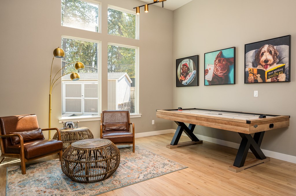 A room with a pool table and three framed pictures on the wall.