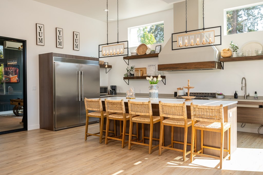 A kitchen with a table and chairs in front of a refrigerator.