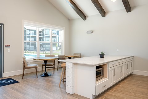 A kitchen with a table and chairs in front of a window.