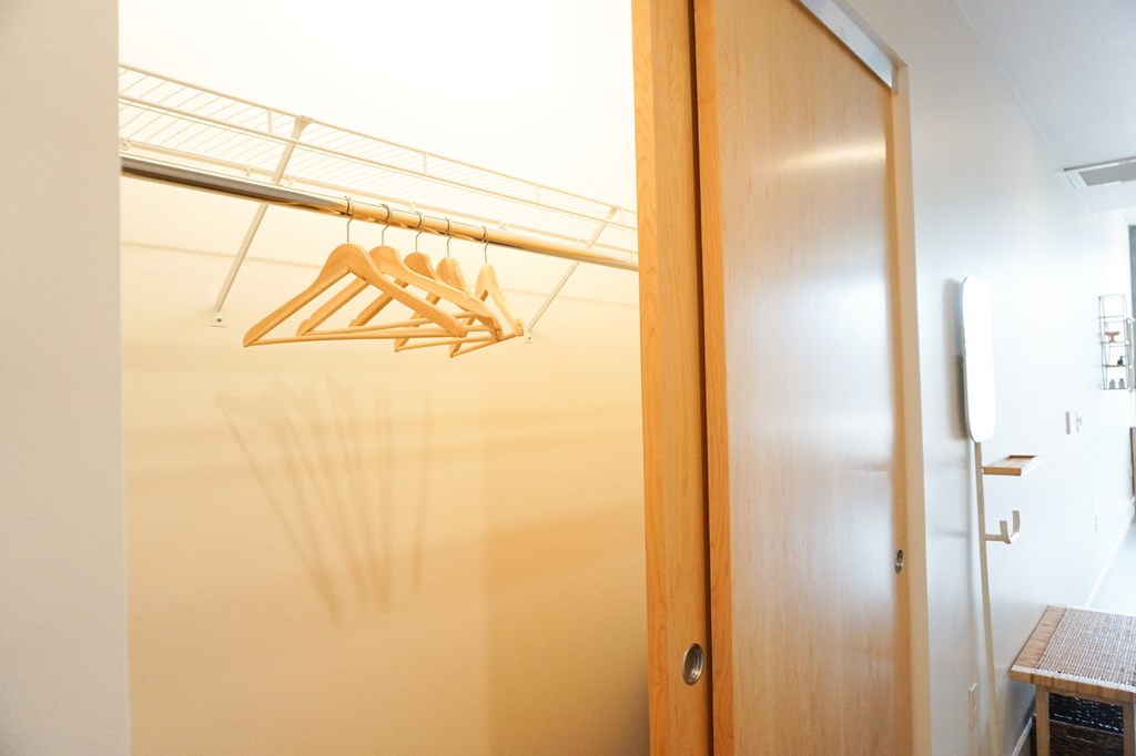 a door to a closet with hooks on the wall