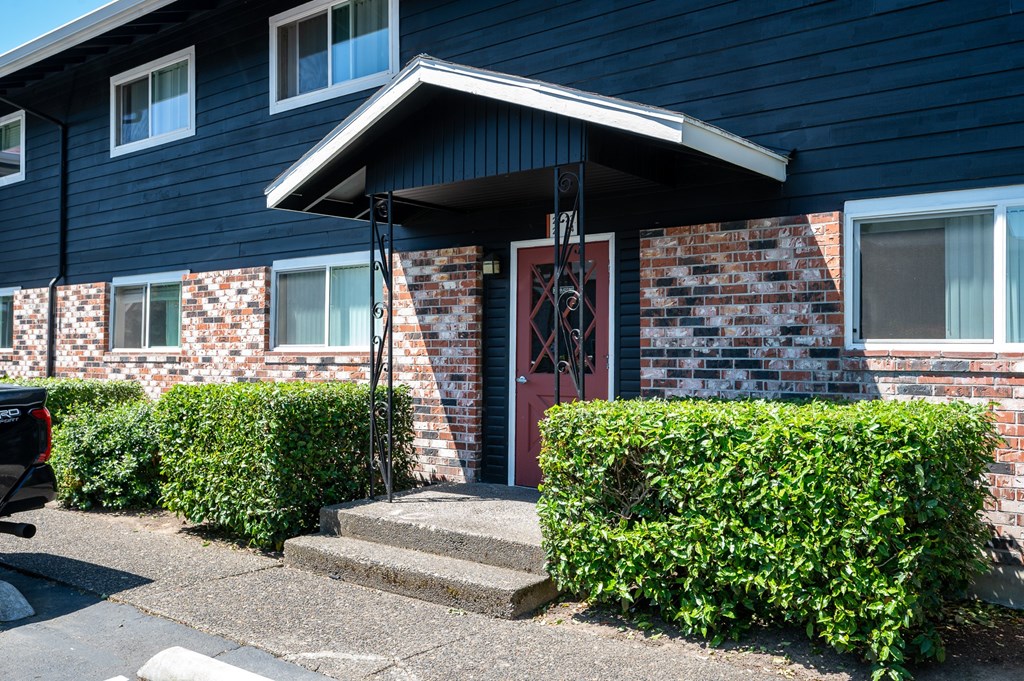 A blue apartment building with a red door