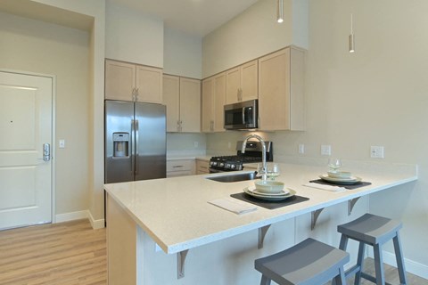 a kitchen with a large island and a stainless steel refrigerator