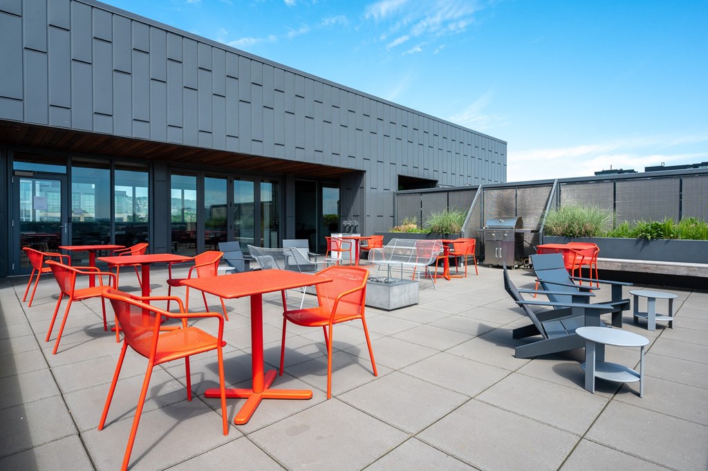 an outdoor patio with orange tables and chairs