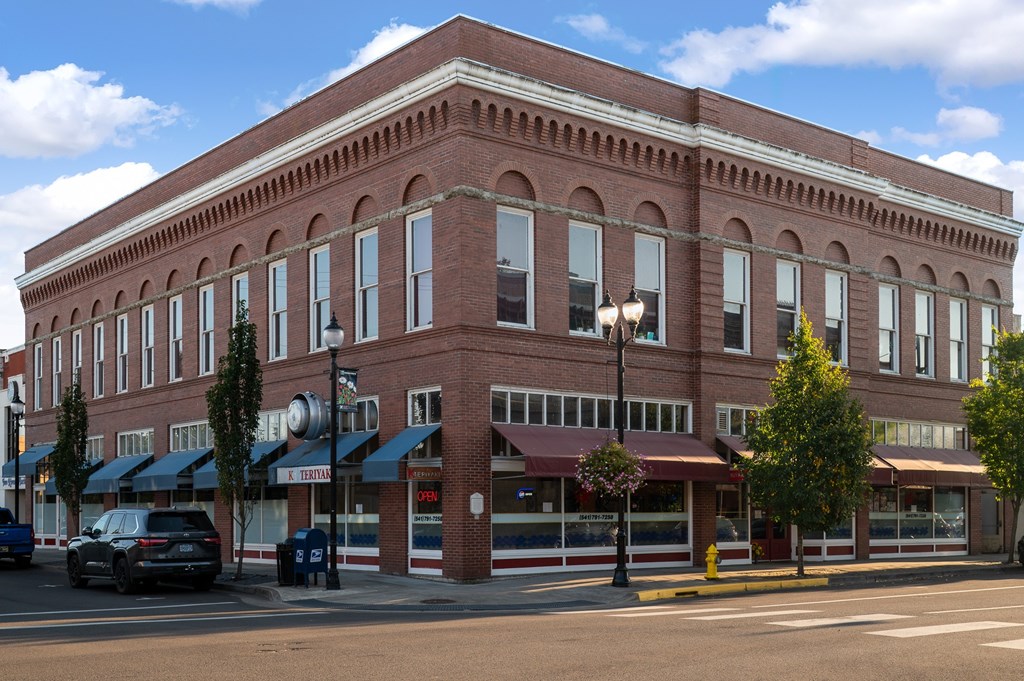 A red brick building with a black car parked in front.