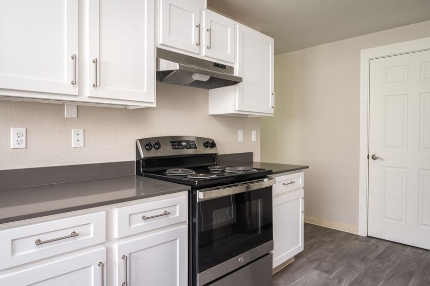 a kitchen with white cabinets and a black stove top oven - Photo Gallery
