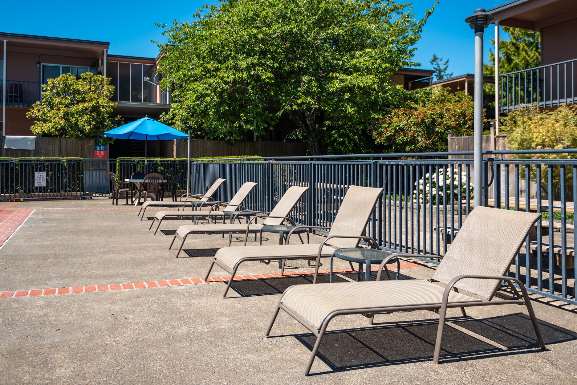 Pool deck showing lounge chairs with tables.