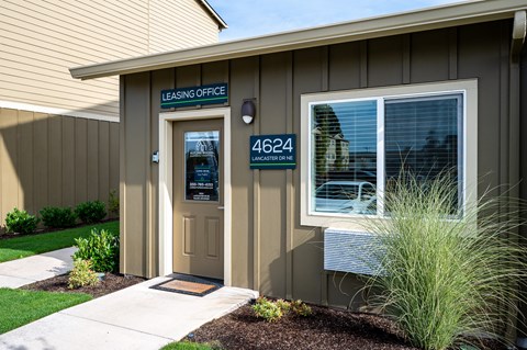 the front of a building with a door and a sign that reads lease office
