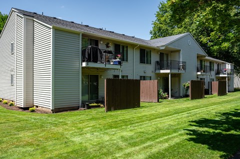A row of houses with green lawns in front.