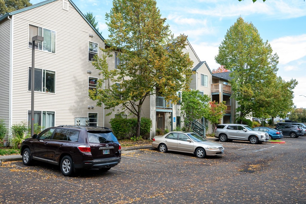 an apartment building with cars parked in a parking lot