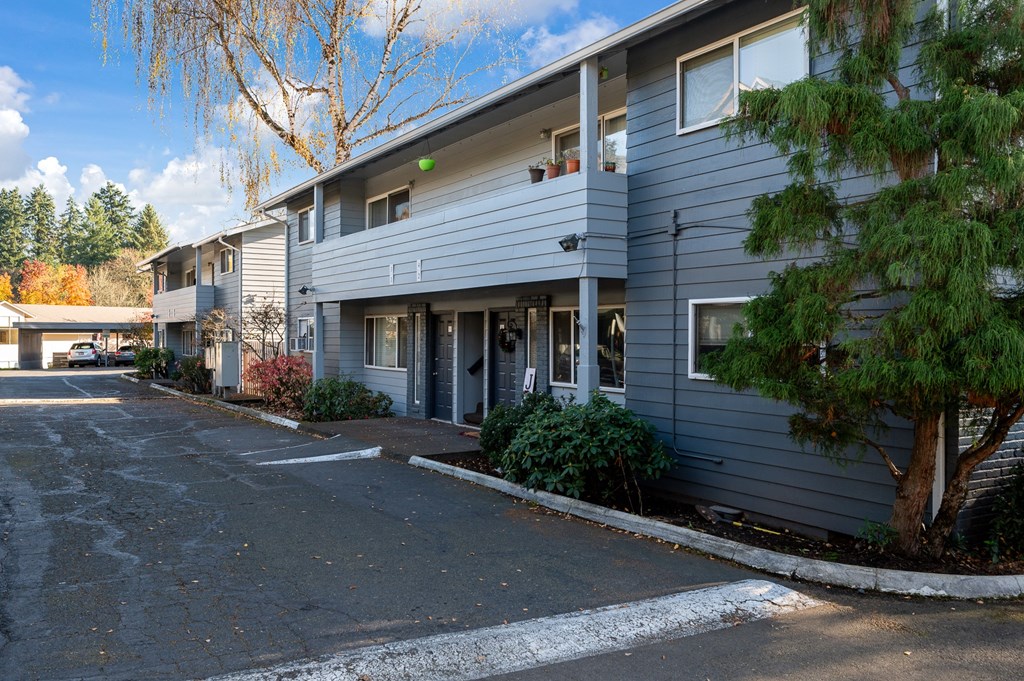 the exterior of a condo building with a parking lot