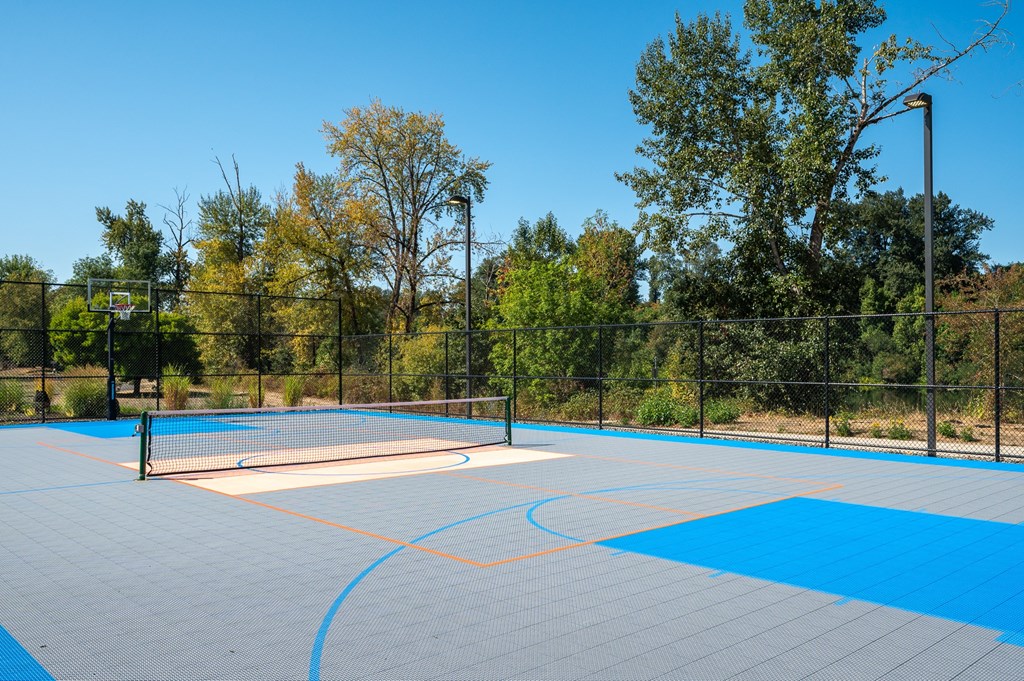 A tennis court with a blue surface and a white net.