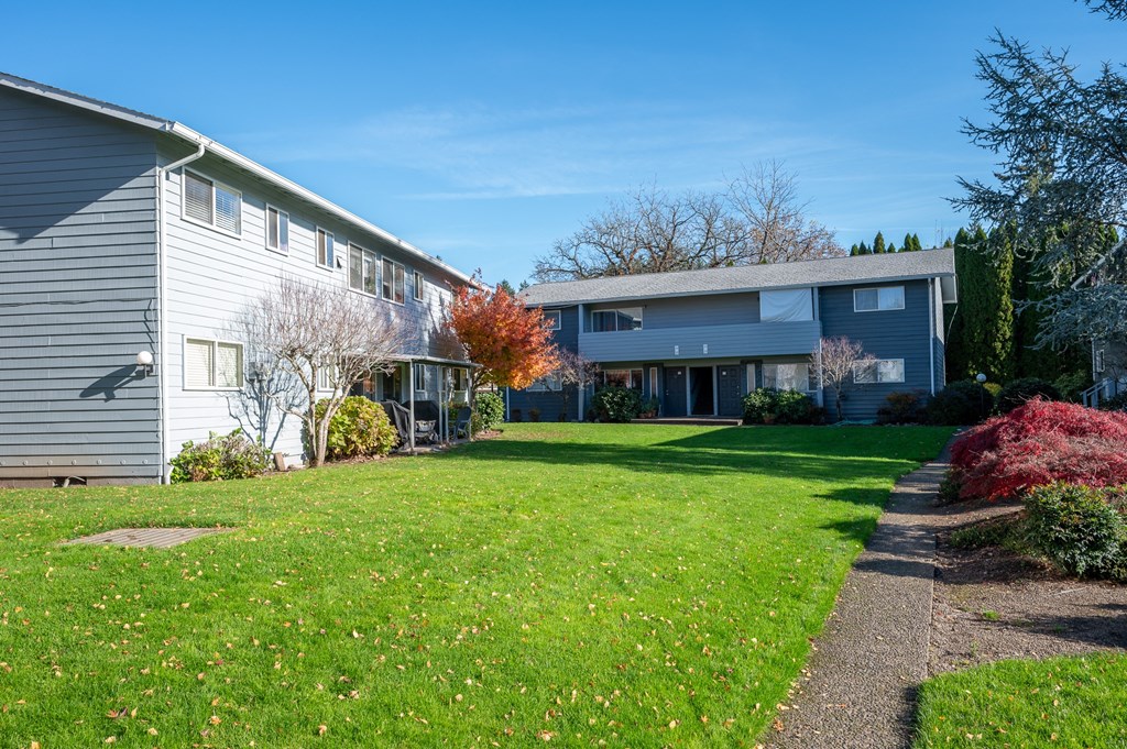 the exterior of a house with a green lawn and a sidewalk