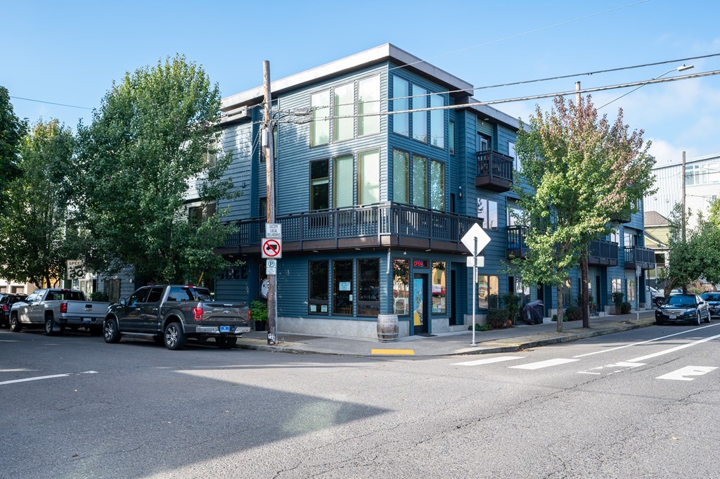 a city street with cars parked in front of a blue building