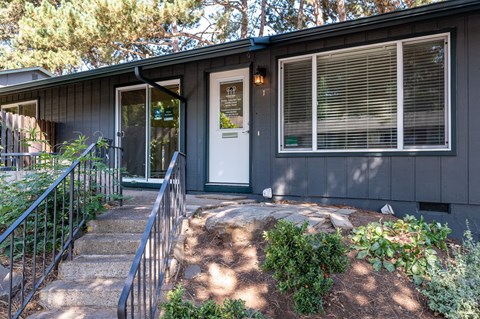 the front entrance of a house with a white door and stairs