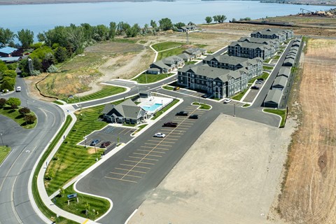 A parking lot with a road and a building in the background.