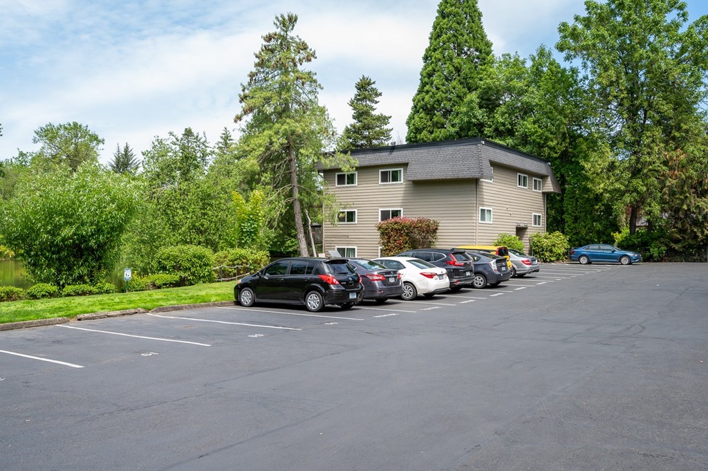 A parking lot with cars and a building in the background.