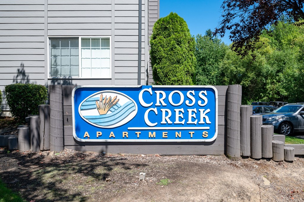a sign in front of a building that says cross creek apartments