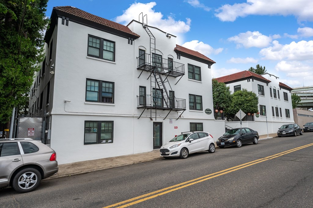 a white building with a fire escape on a city street