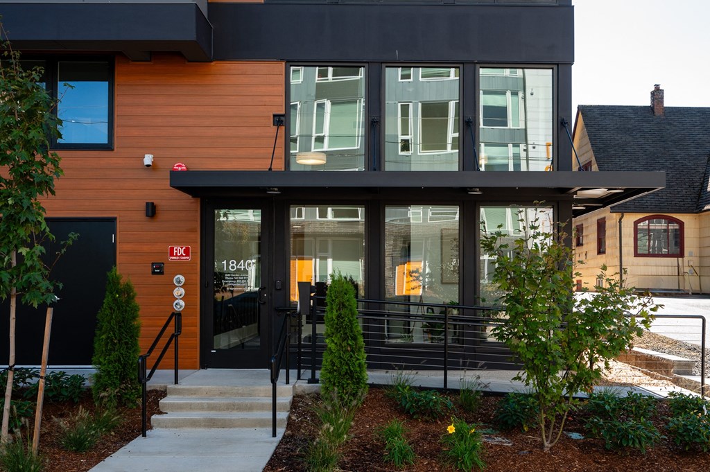 the front of a building with glass doors and a staircase