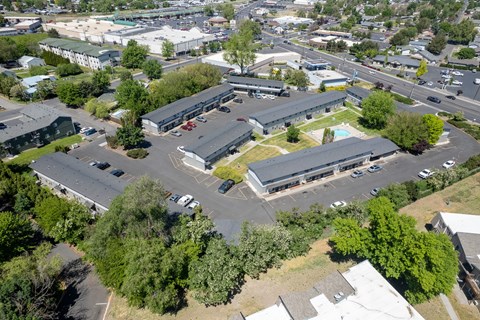 An aerial view of a parking lot with a building in the background.