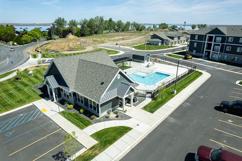 A view of a parking lot with a building and a pool.