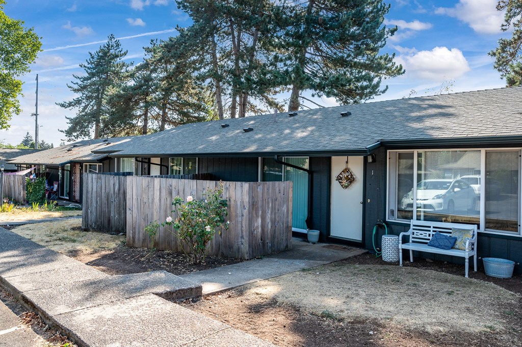 a house with a fence and a chair in front of it