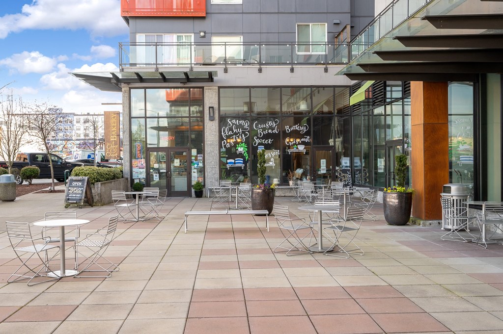 a patio with tables and chairs outside of a building