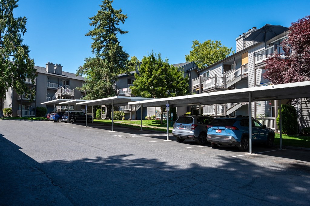 a row of apartment buildings with cars parked in front of them